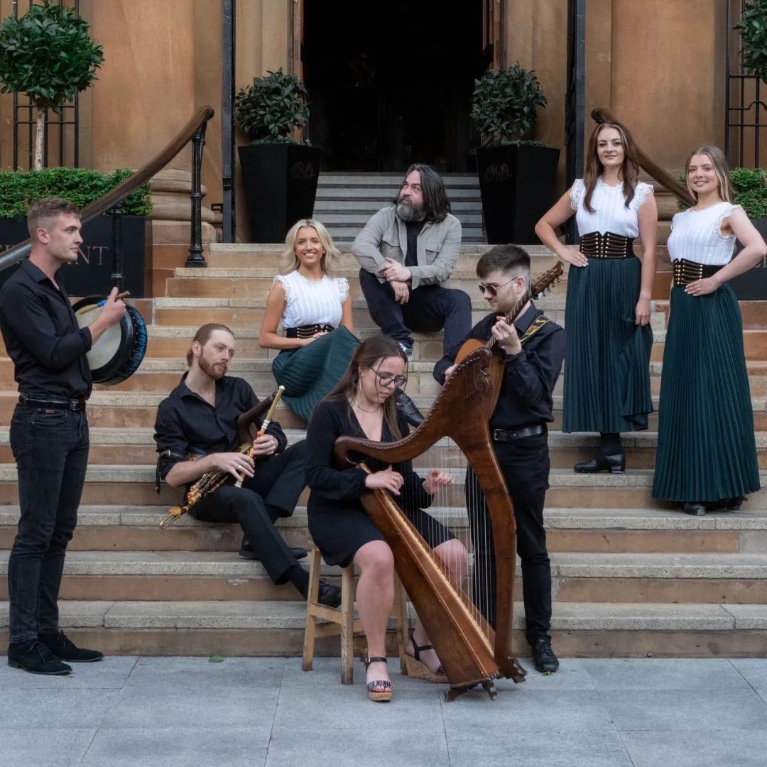 Belfast Hidden Tours guides in period costume with instruments, photographed on a stone staircase